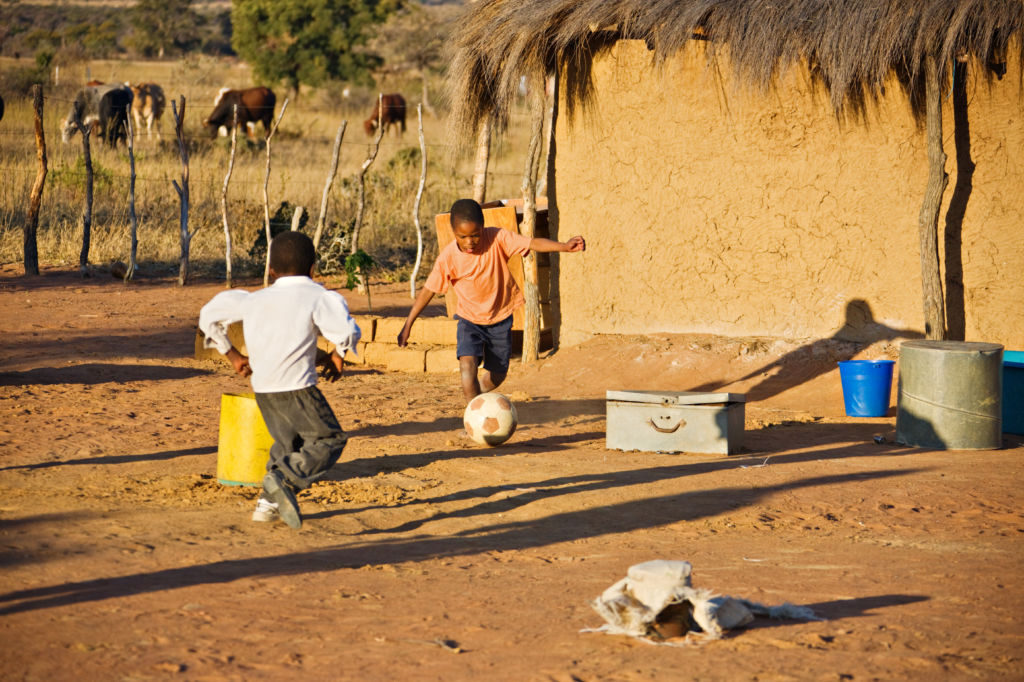 Niños jugando en el patio de una casa al fútbol