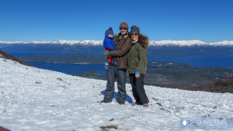 Familia en un paisaje nevado con montañas al fondo en Villa La Angostura, Argentina
