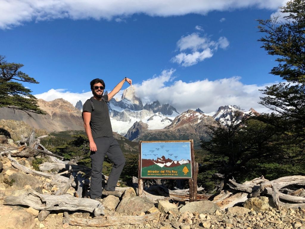 Hombre delante del carte del mirado Fitz Roy en el Chaltén, Argentina