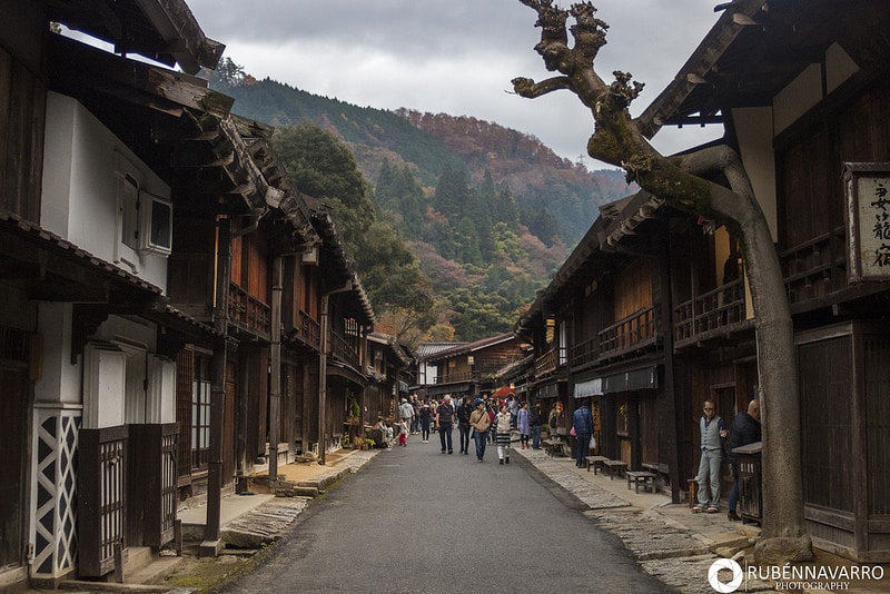 Vistas de una calle con casas tradicionales y una montaña de fondo e n la ruta Nakasendo en Japón