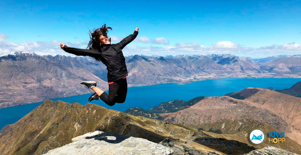 Mujer saltando en la montaña en Nueva Zelanda