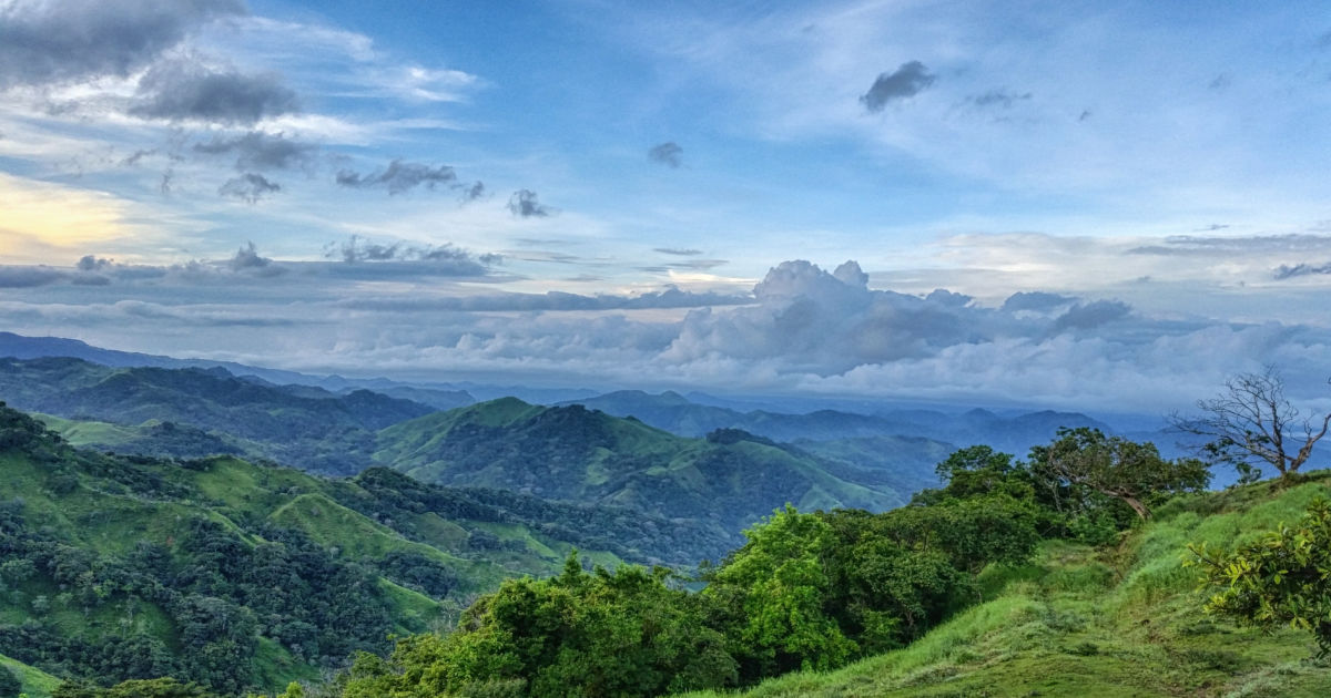 Paisaje de montañas verdes y cielo azul en Costa Rica