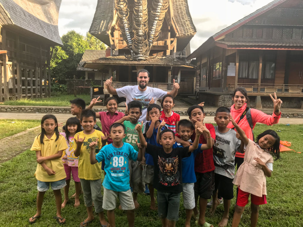 Grupo de niños con un hombre saludando en Raja Ampat en Indonesia