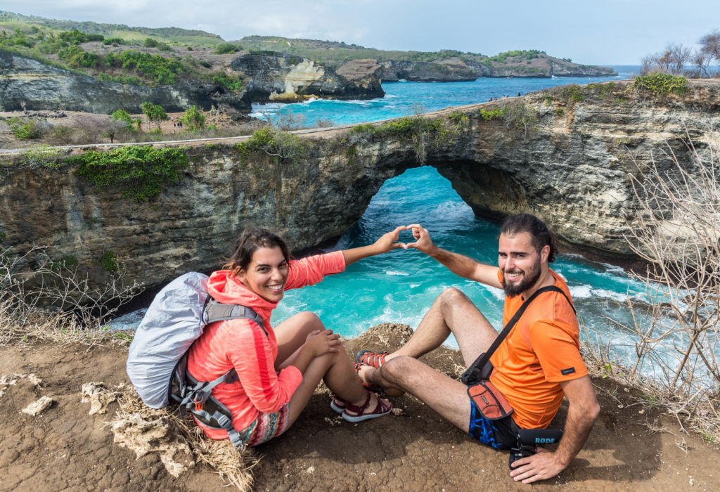 Pareja haciendo el símbolo del corazón con la mano en Broken Beach, Nusa Penida, Indonesia